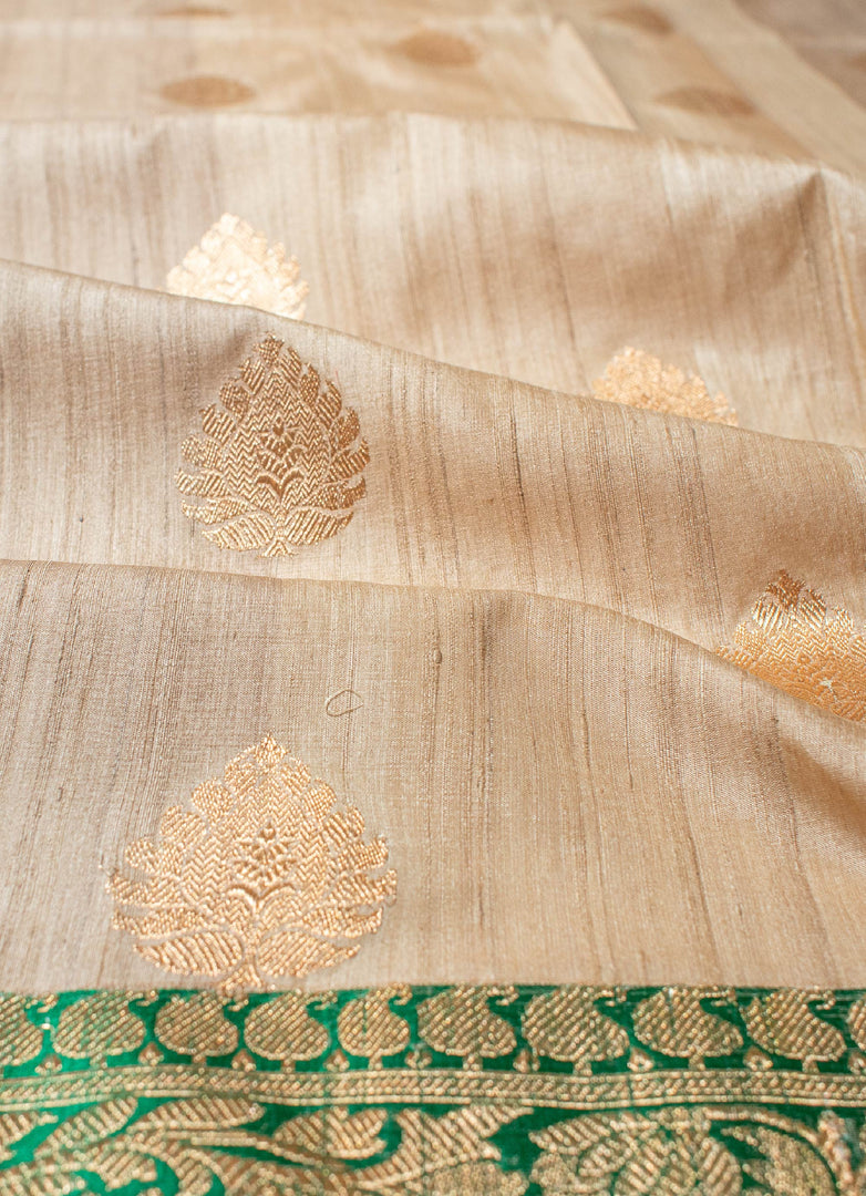 Beige color tussar silk saree with red and green border